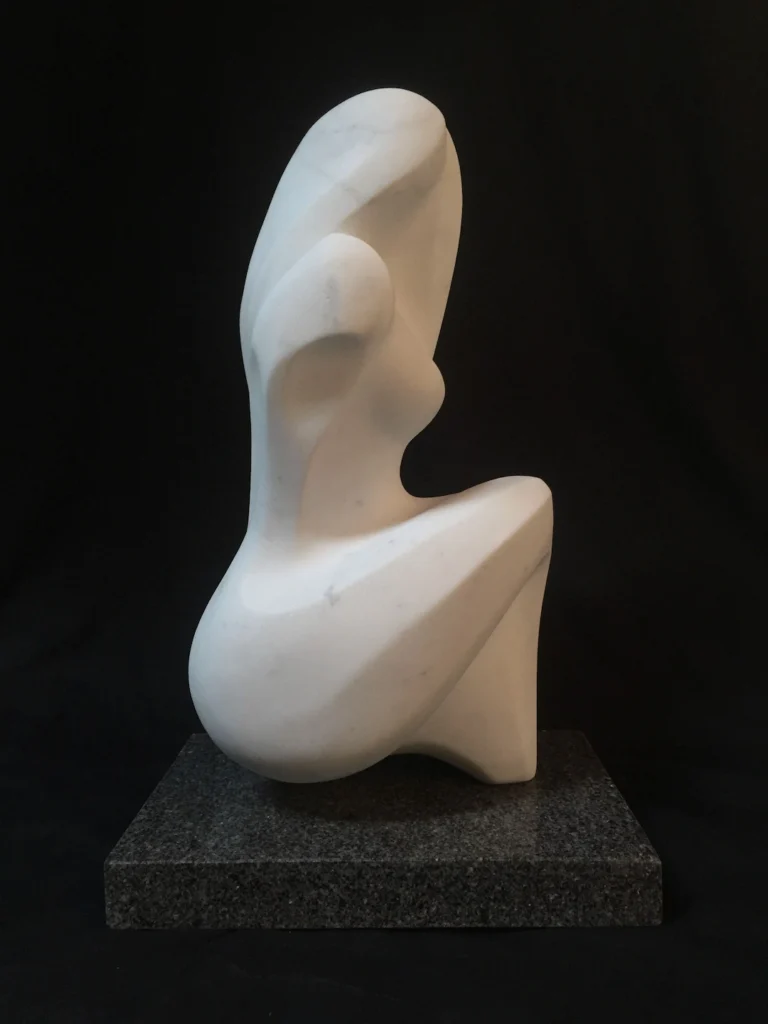 A white sculpture of a seated woman displayed on a sleek black base.
