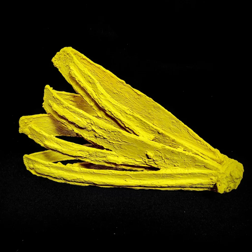 A single yellow banana resting on a solid black background.