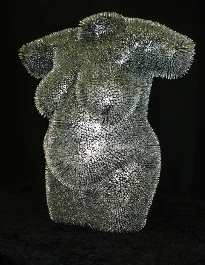 A sculpture composed of intricate metal pins arranged in a dynamic, abstract design.